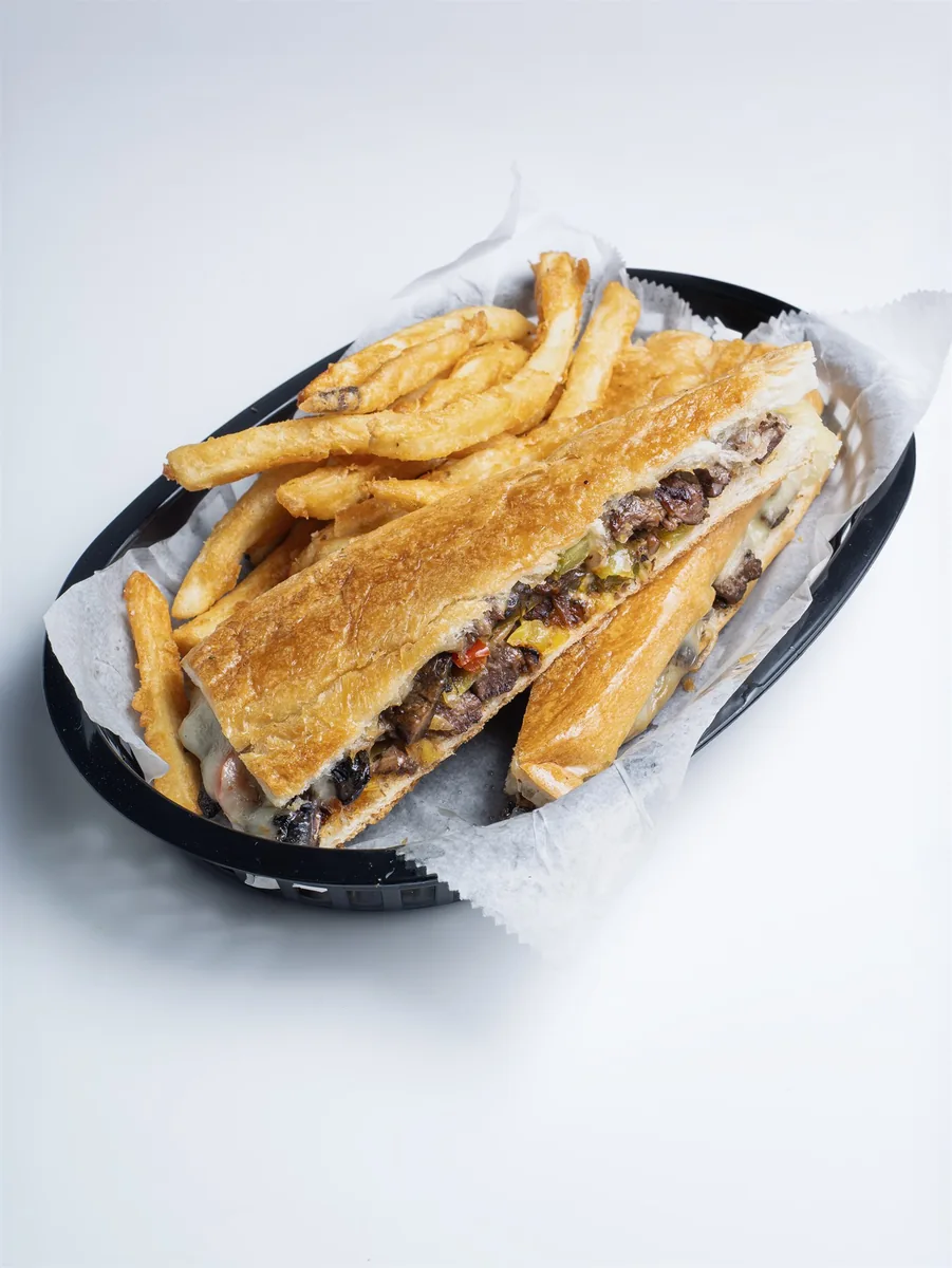 Steak sandwich de Mejunje servido con papitas fritas